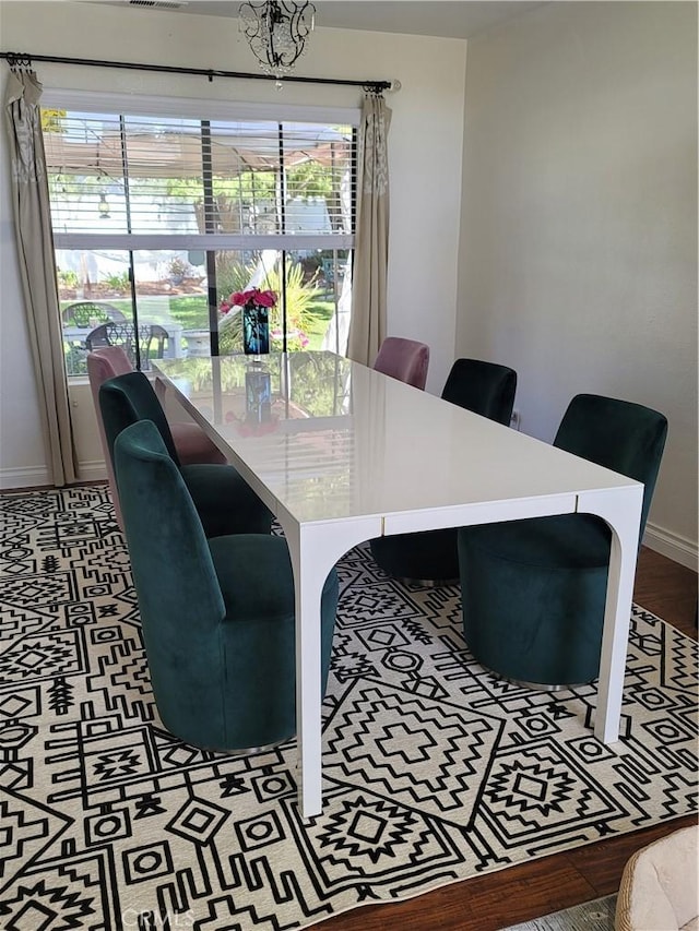 dining area featuring baseboards and a notable chandelier