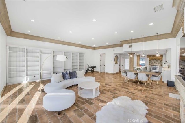 living room with brick floor, recessed lighting, visible vents, and crown molding