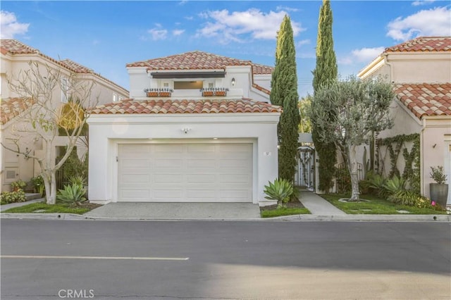 mediterranean / spanish house with driveway, a tile roof, and stucco siding