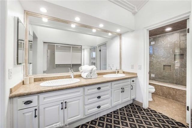 bathroom featuring toilet, double vanity, and a sink