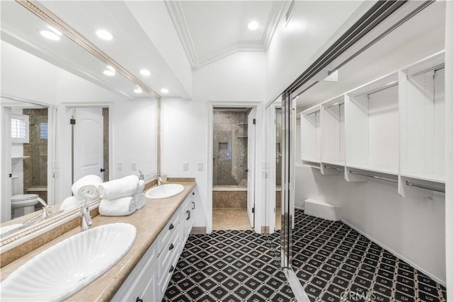 full bath with double vanity, a sink, toilet, and crown molding