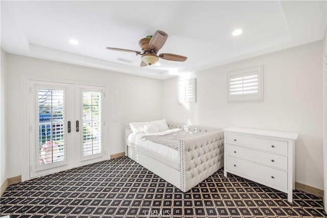 bedroom featuring access to exterior, a raised ceiling, visible vents, and baseboards