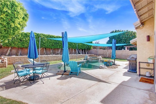 view of patio with outdoor dining area, a fenced backyard, and a pool with connected hot tub