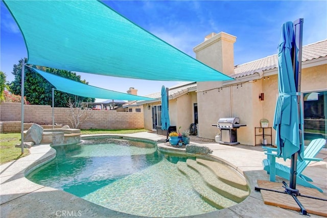 view of swimming pool with a fenced backyard, a pool with connected hot tub, grilling area, and a patio