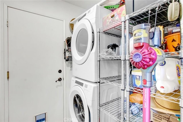 laundry room with stacked washer and dryer and laundry area