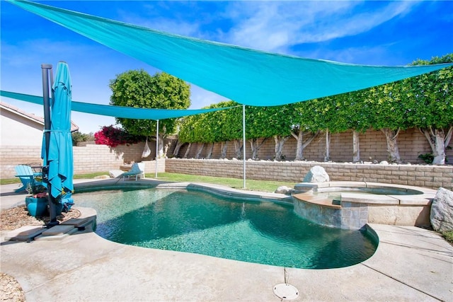 view of pool with a fenced backyard and a pool with connected hot tub