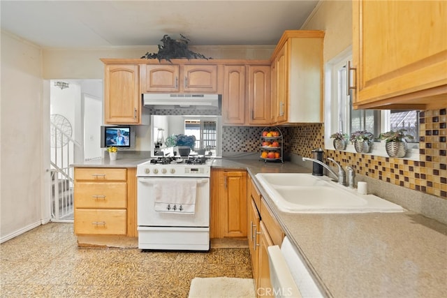 kitchen featuring under cabinet range hood, a sink, white range with gas cooktop, ornamental molding, and tasteful backsplash