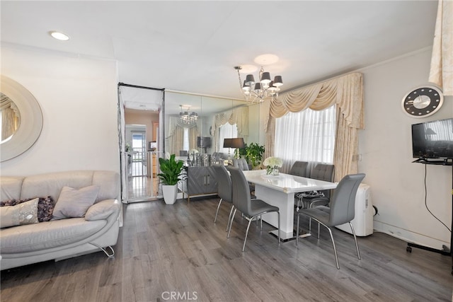 dining room featuring an inviting chandelier, baseboards, ornamental molding, and wood finished floors