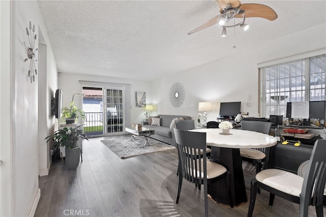 dining area featuring a textured ceiling, wood finished floors, and a ceiling fan