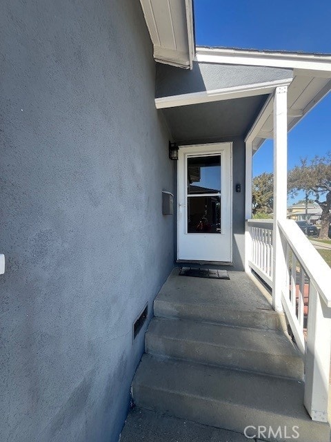 view of exterior entry featuring crawl space and stucco siding