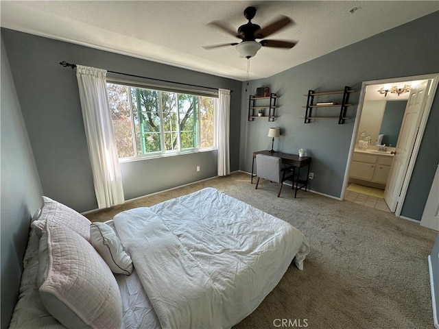 bedroom featuring lofted ceiling, light colored carpet, ensuite bathroom, ceiling fan, and baseboards