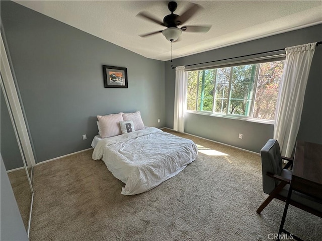 bedroom with a textured ceiling, carpet, and a ceiling fan