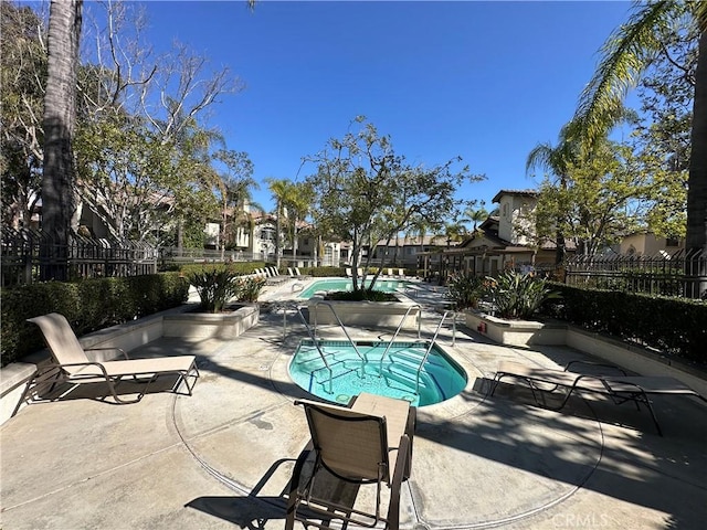 community pool with fence and a patio