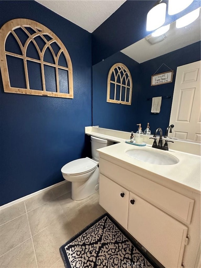 half bath featuring tile patterned flooring, baseboards, vanity, and toilet