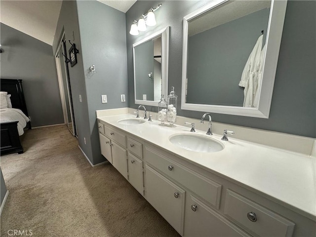 full bathroom with double vanity, a sink, and connected bathroom