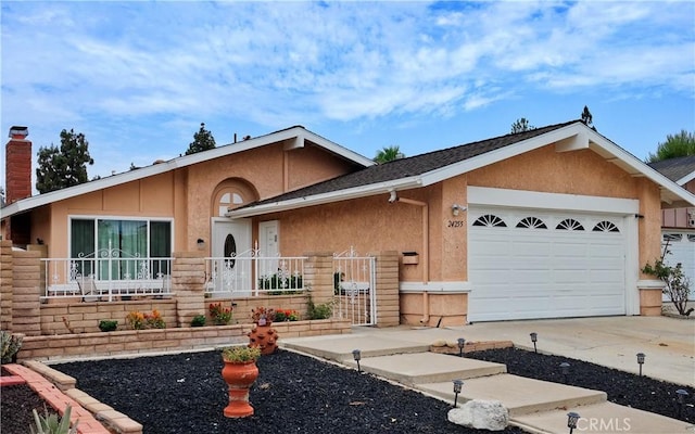 view of front of home featuring a garage, concrete driveway, and stucco siding