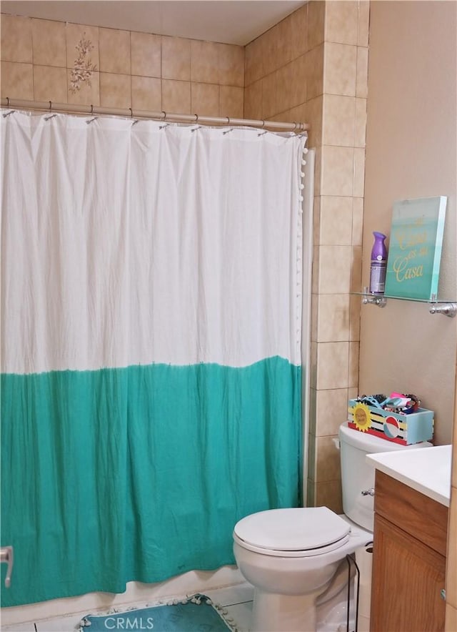 bathroom featuring a shower with shower curtain, vanity, and toilet