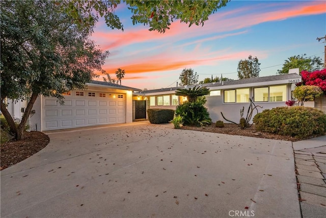 ranch-style home with a garage, driveway, and stucco siding