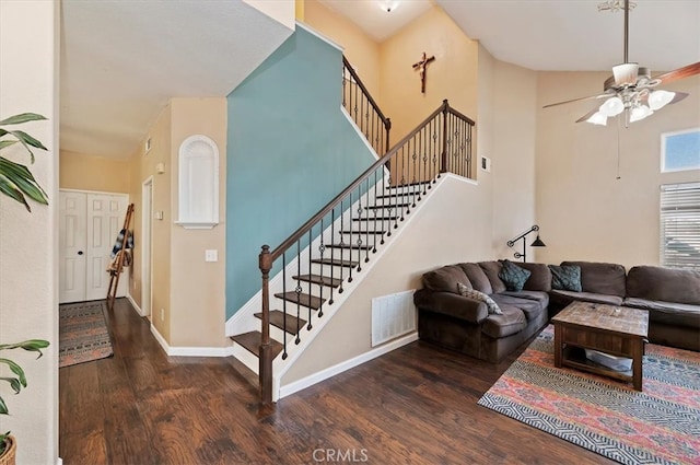 living room featuring stairway, wood finished floors, visible vents, and baseboards