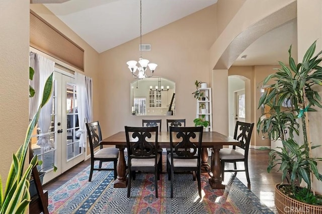 dining area with arched walkways, french doors, wood finished floors, and visible vents