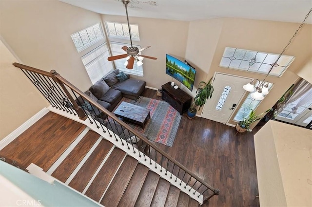 living room featuring baseboards, stairway, and wood finished floors