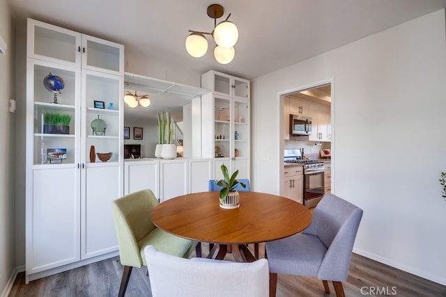 dining space featuring dark wood-style floors and a chandelier