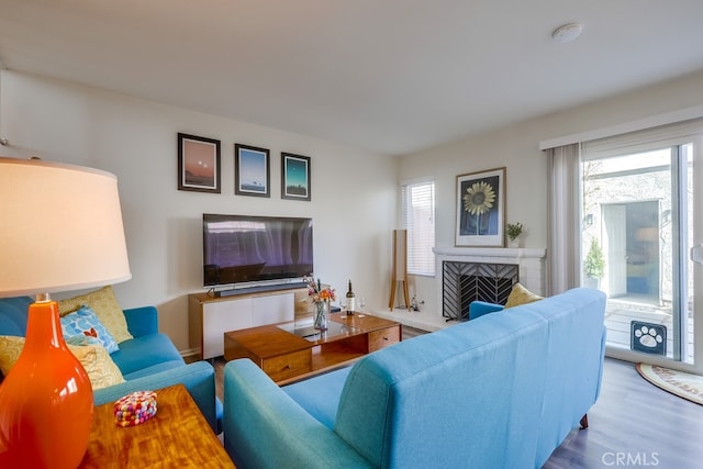 living area with a brick fireplace and wood finished floors