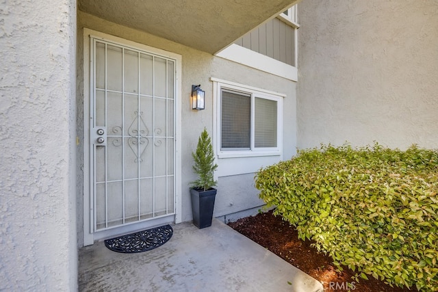 view of exterior entry with stucco siding