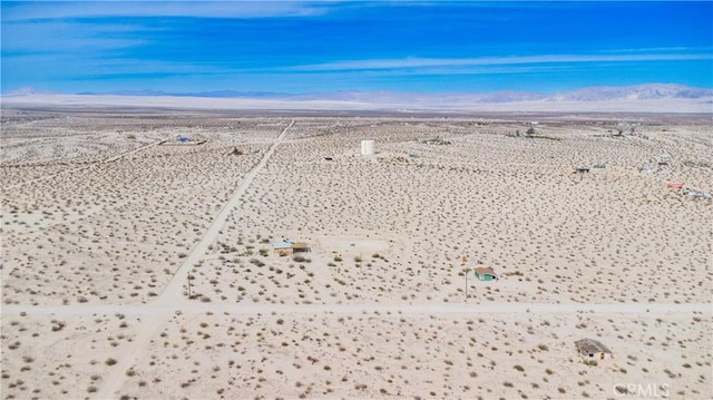 drone / aerial view featuring a desert view and a mountain view