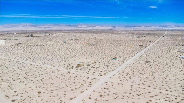 drone / aerial view featuring a rural view, a desert view, and a mountain view