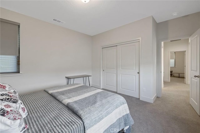 bedroom with carpet, a closet, visible vents, and baseboards