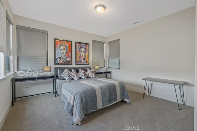 carpeted bedroom featuring baseboards and visible vents