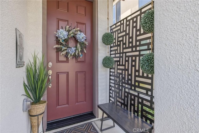 entrance to property featuring stucco siding