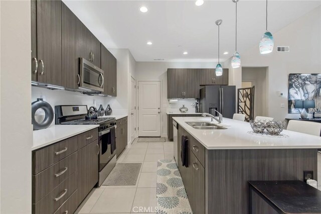 kitchen featuring visible vents, light countertops, stainless steel appliances, a sink, and light tile patterned flooring