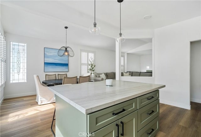 kitchen featuring green cabinets, light countertops, dark wood-type flooring, and baseboards