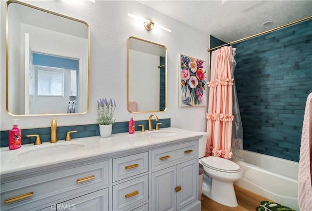 bathroom featuring a textured ceiling, shower / tub combo, a sink, and toilet