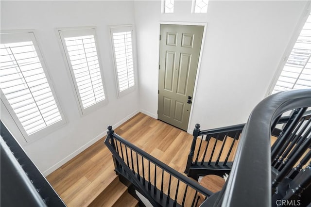 staircase featuring baseboards and wood finished floors