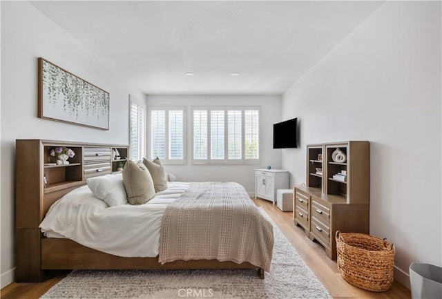 bedroom featuring baseboards and light wood finished floors