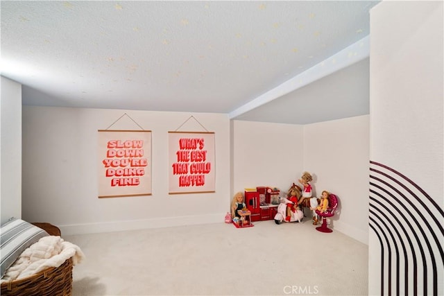 rec room with a textured ceiling, baseboards, and carpet flooring