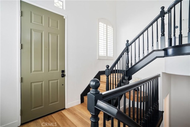 entryway featuring stairs, baseboards, and wood finished floors