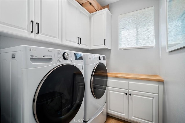 laundry room featuring independent washer and dryer and cabinet space