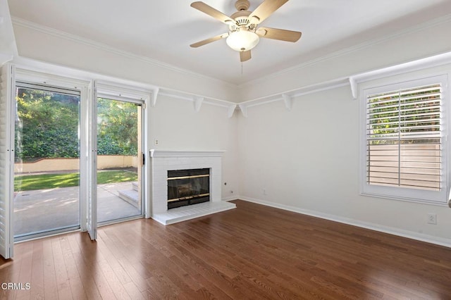 unfurnished living room with a healthy amount of sunlight, hardwood / wood-style flooring, a fireplace, and baseboards