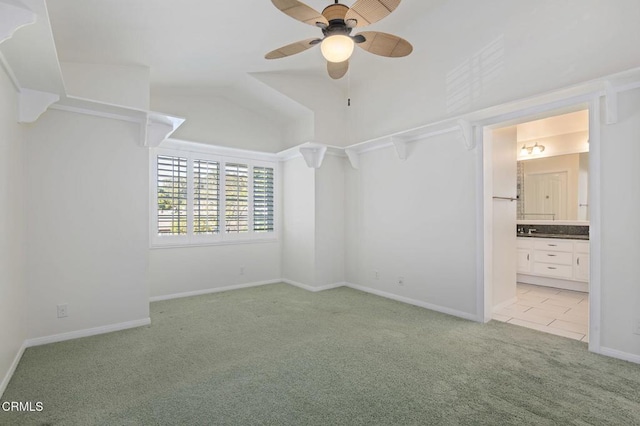 unfurnished bedroom with carpet floors, lofted ceiling, a ceiling fan, connected bathroom, and baseboards