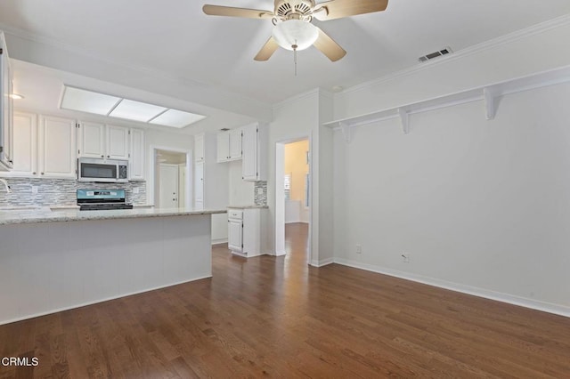 kitchen with visible vents, white cabinetry, appliances with stainless steel finishes, decorative backsplash, and dark wood finished floors