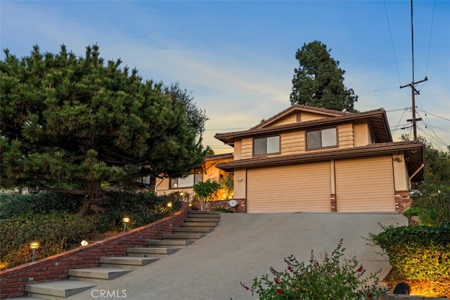 view of front of property with driveway, an attached garage, and brick siding