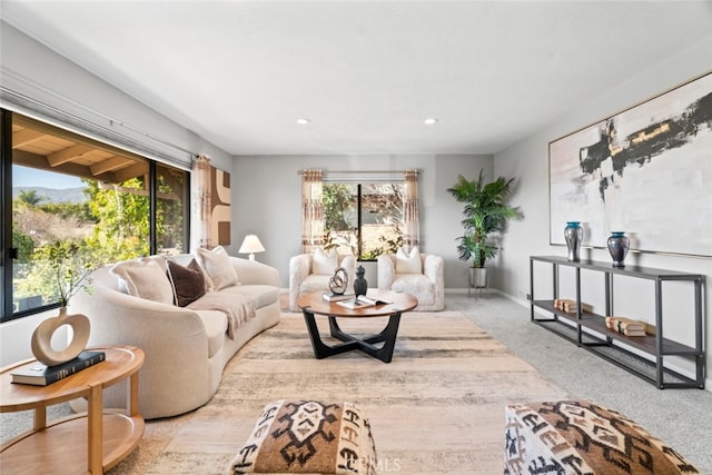 carpeted living area with recessed lighting and baseboards