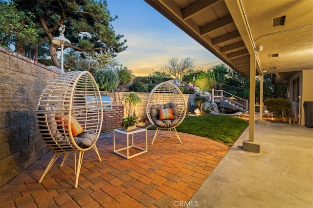 patio terrace at dusk with stairs and a fenced backyard