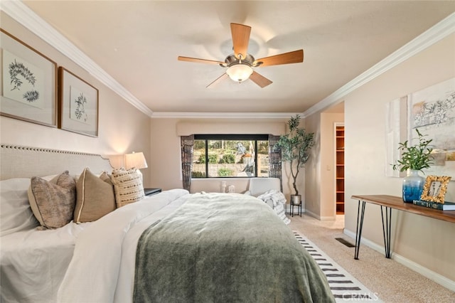 bedroom with a walk in closet, light colored carpet, ornamental molding, ceiling fan, and baseboards