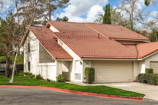 mediterranean / spanish-style home featuring a garage, concrete driveway, a tiled roof, and stucco siding