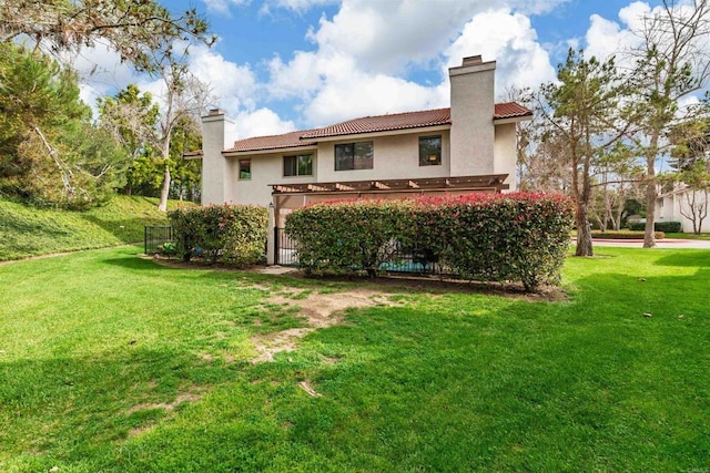 back of house featuring a yard, a chimney, and stucco siding